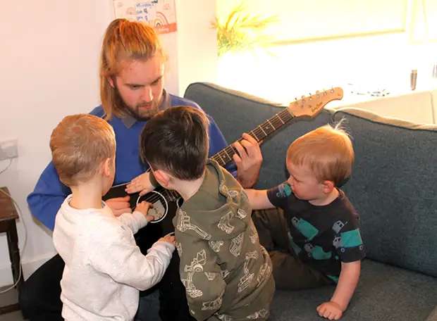 Guitar playing with children at Home From Home nurseries.